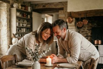 Couple marié célébrant leur anniversaire de mariage autour d'un dîner intime dans une cuisine en pierre rustique