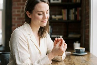 Femme souriante admire une bague diamant solitaire