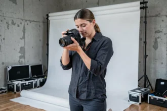 Photographe professionnelle en studio à Saint-Denis ajustant son appareil photo reflex numérique